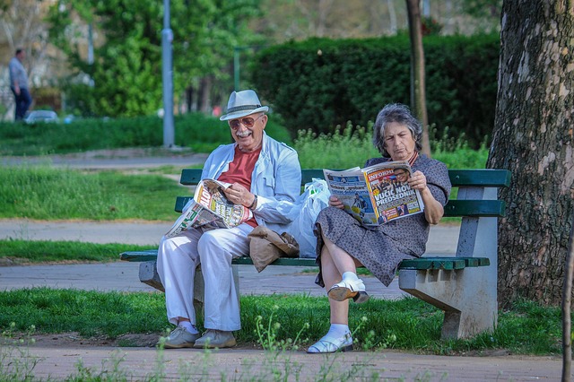 důchodci s novinami